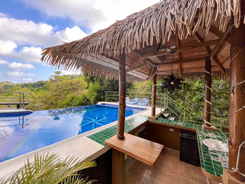 This magnificent villa features a large luxury pool, enveloped by lush tropical rainforest surroundings.