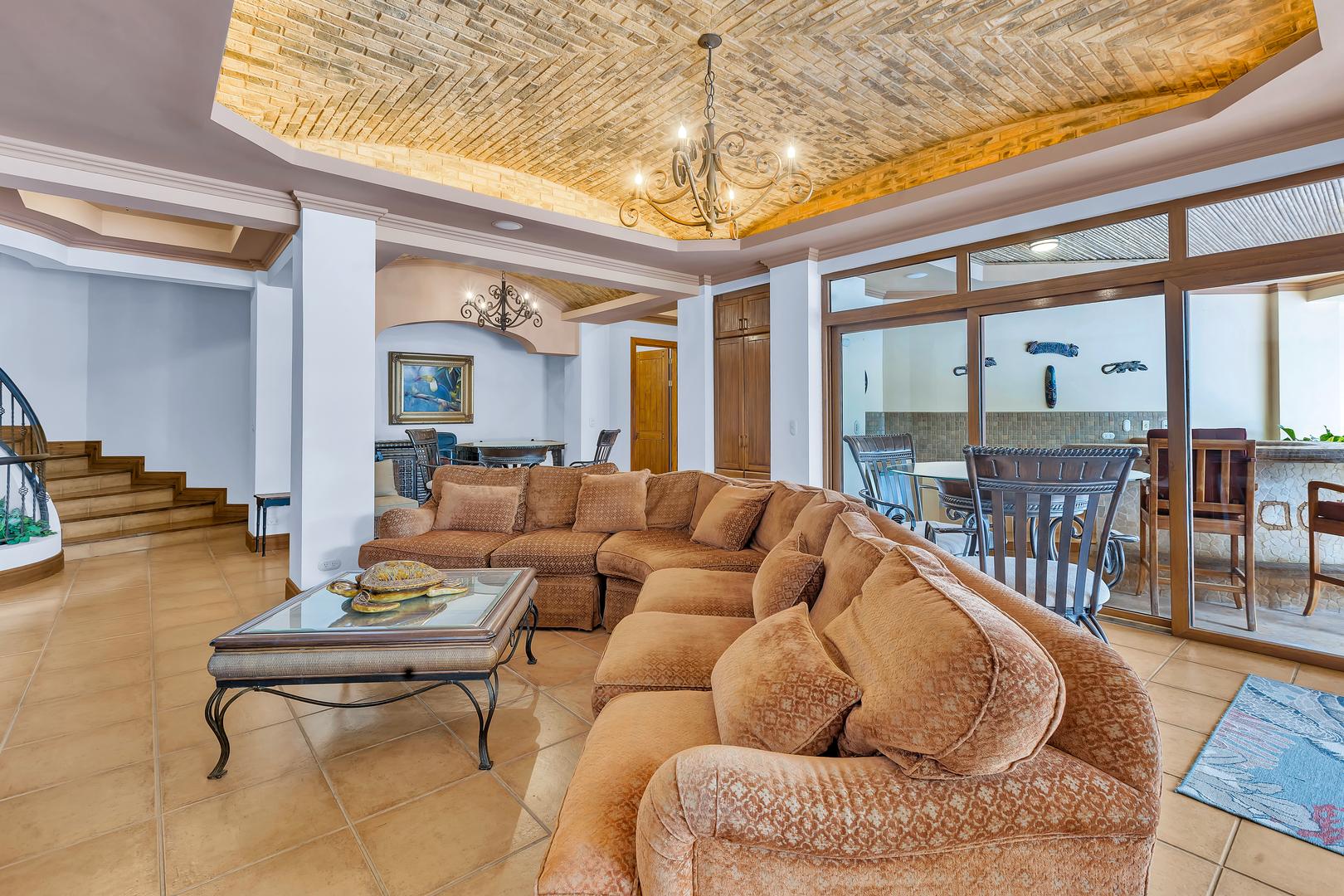 Lower-level lounge with sectional seating and covered outdoor entertainment area in a luxury beachfront villa in Costa Rica.