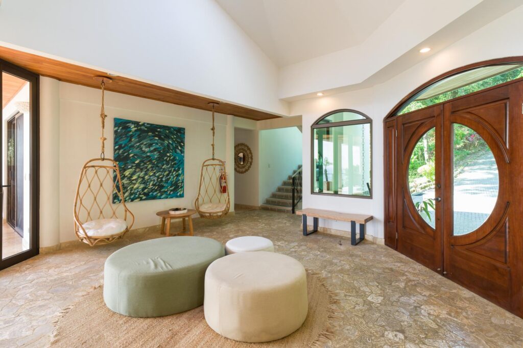 A fresh and inviting entry lounge with playful hanging chairs, warm natural textures, and artistic details that create an easy, relaxed vibe from the moment you arrive.