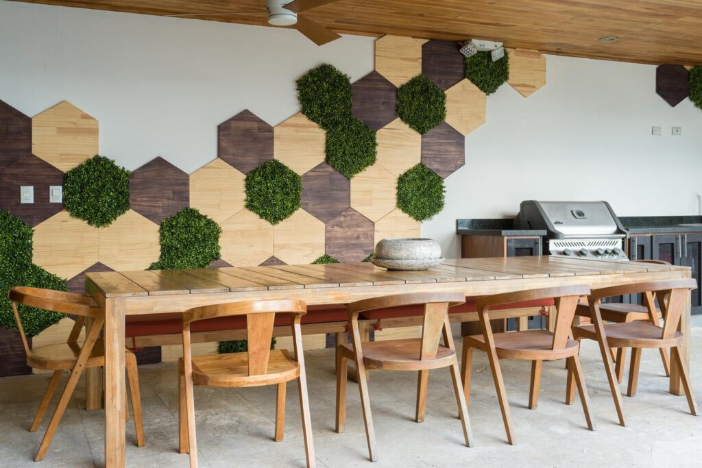 A stylish outdoor dining space with warm wood finishes, fresh geometric accents, and a built-in grill—ideal for easy, open-air meals.