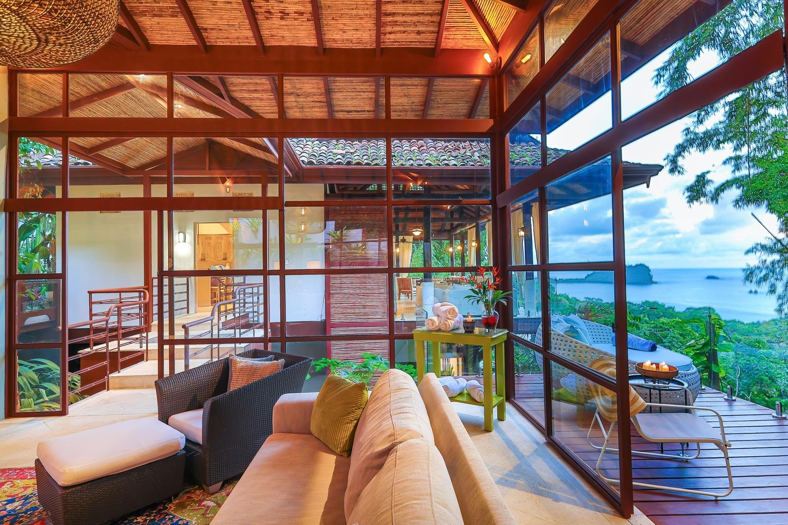 Glass-walled lounge with seating and ocean view in the new wing of Casa Vista Azul