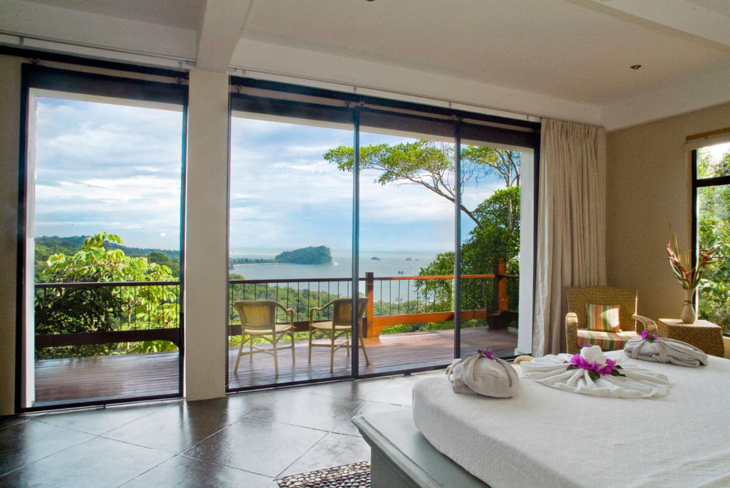 Bedroom with sliding glass doors opening to ocean view terrace in Manuel Antonio Costa Rica