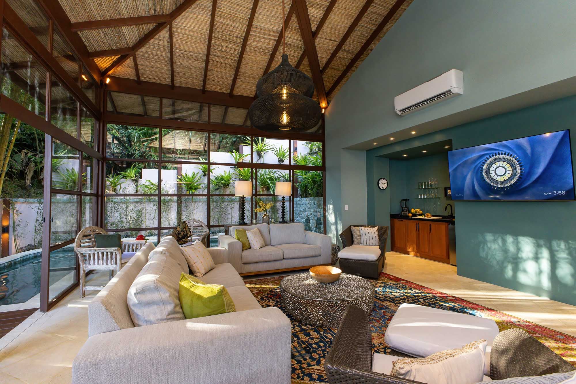 Open-plan interior lounge of the new wing with vaulted ceiling, woven textures, soft seating, and jungle views at a luxury villa in Manuel Antonio, Costa Rica.
