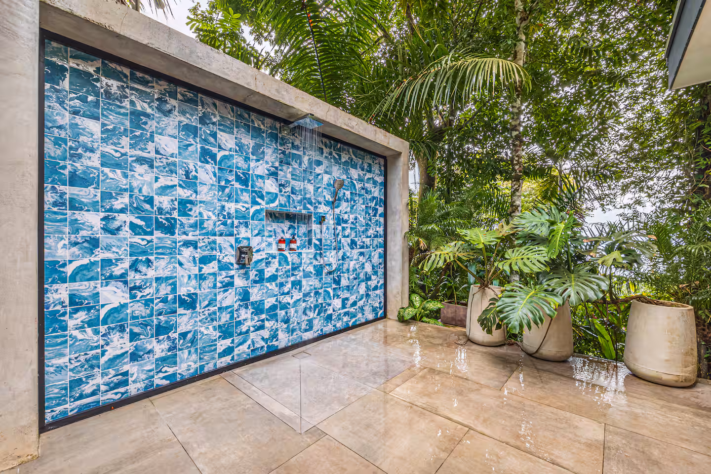 Outdoor rainfall shower with blue tiled wall surrounded by tropical plants at a luxury jungle villa near Dominical, Costa Rica.