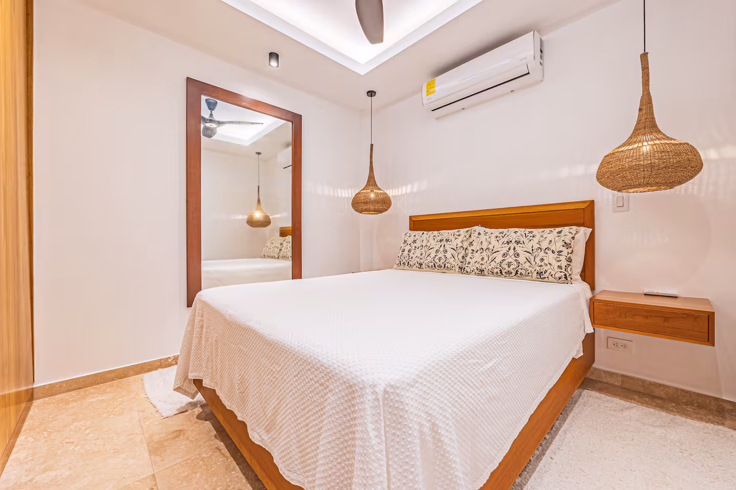 Guest bedroom with queen bed, wooden furniture, and woven pendant lights in a villa near Dominical, Costa Rica.