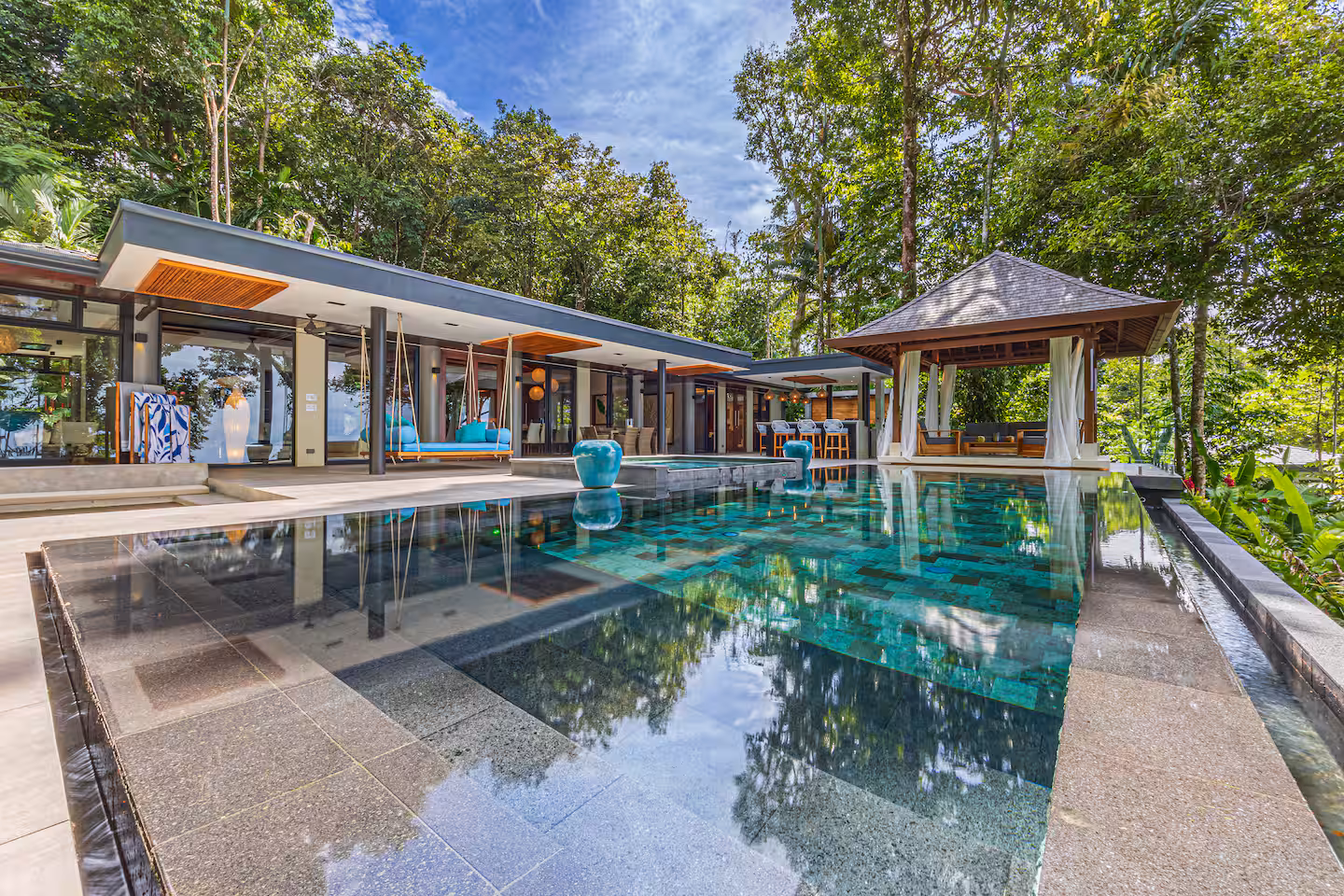 Infinity pool with modern open-air villa surrounded by tropical rainforest near Dominical, Costa Rica.