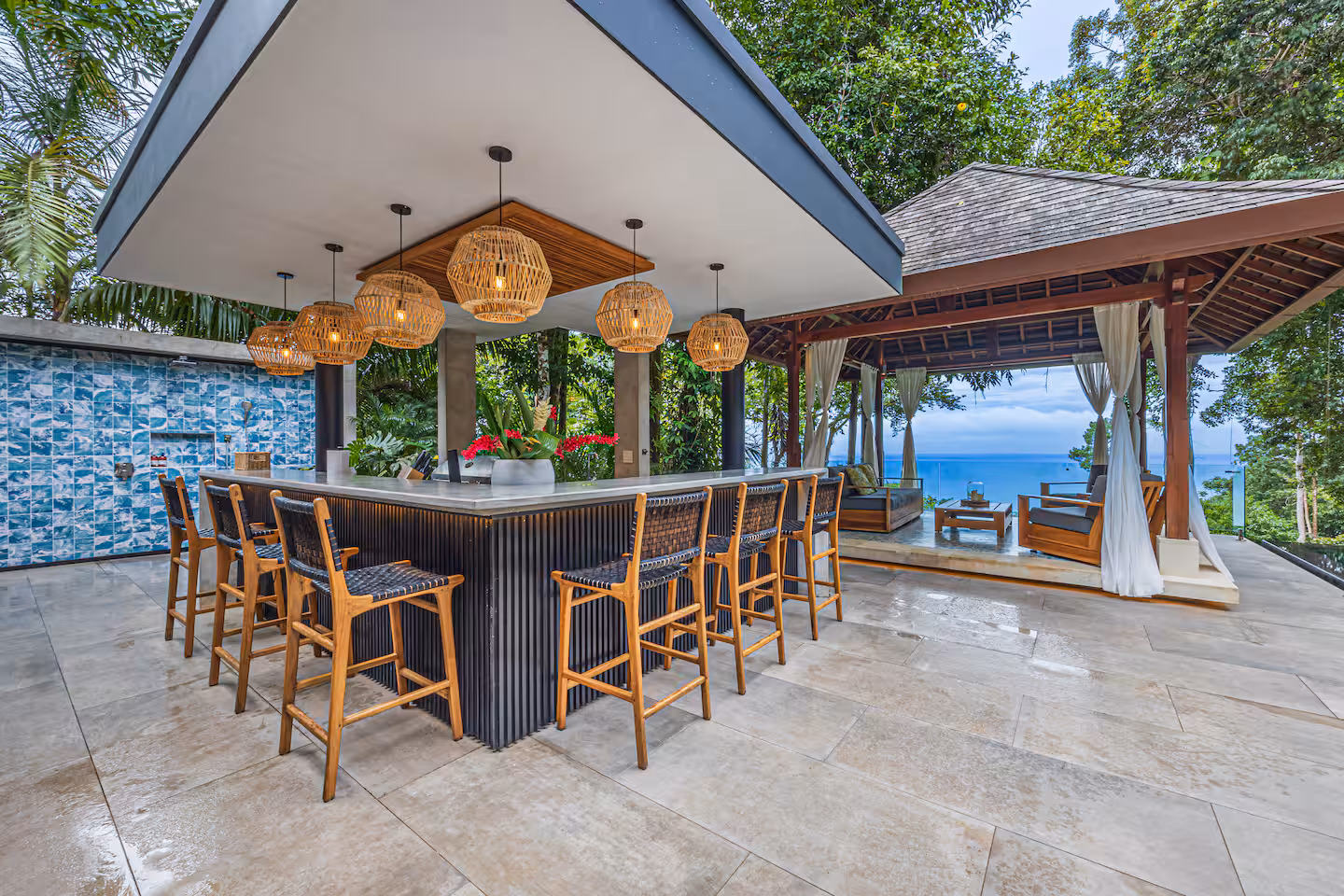 Covered outdoor bar with seating and lounge pavilion overlooking the ocean at a luxury villa near Dominical, Costa Rica.