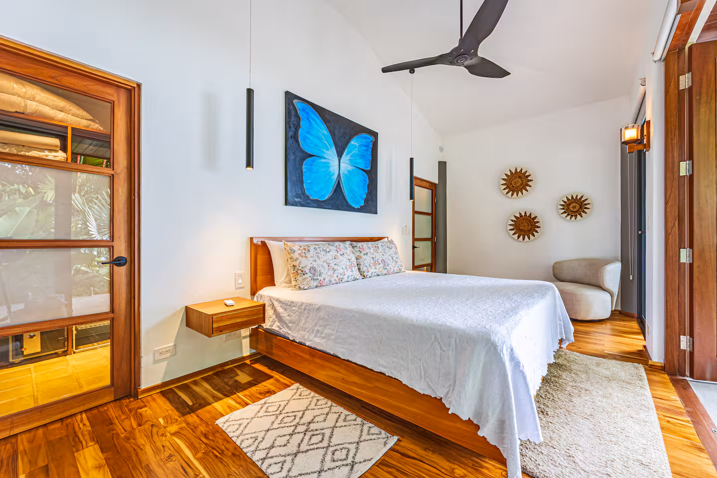 Bedroom with wood floors, king bed, and decorative artwork in a luxury villa near Dominical, Costa Rica.