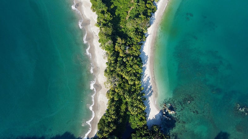 Aerial view of tropical rainforest separating two white-sand beaches in Manuel Antonio National Park, Costa Rica.