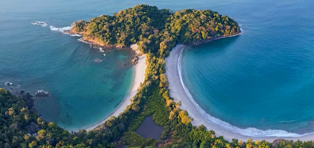 Discover the iconic beauty of Manuel Antonio National Park, where Cathedral Point connects two pristine beaches surrounded by lush tropical rainforest.