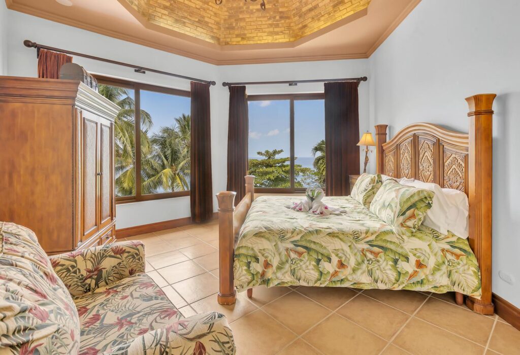 Morning light shines through the palms, filling this bedroom with calm ocean views.
