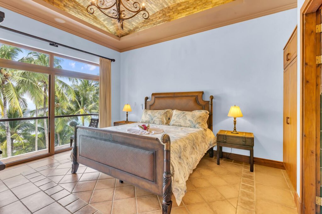 A peaceful bedroom with soft light and palm views.