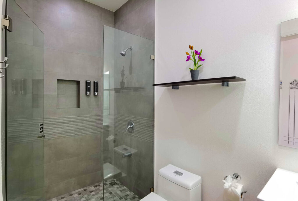This tastefully-designed bathroom has a huge glass-door shower.