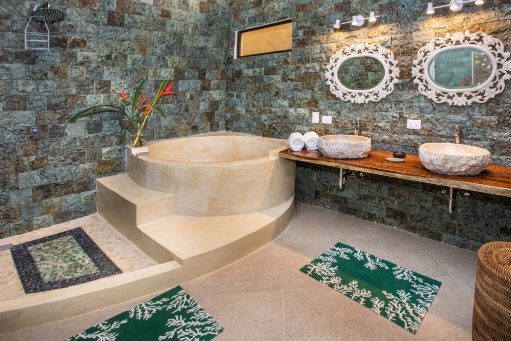 This amazing bathroom features his and hers natural stone sinks and a gorgeous relaxing marble bath tub.