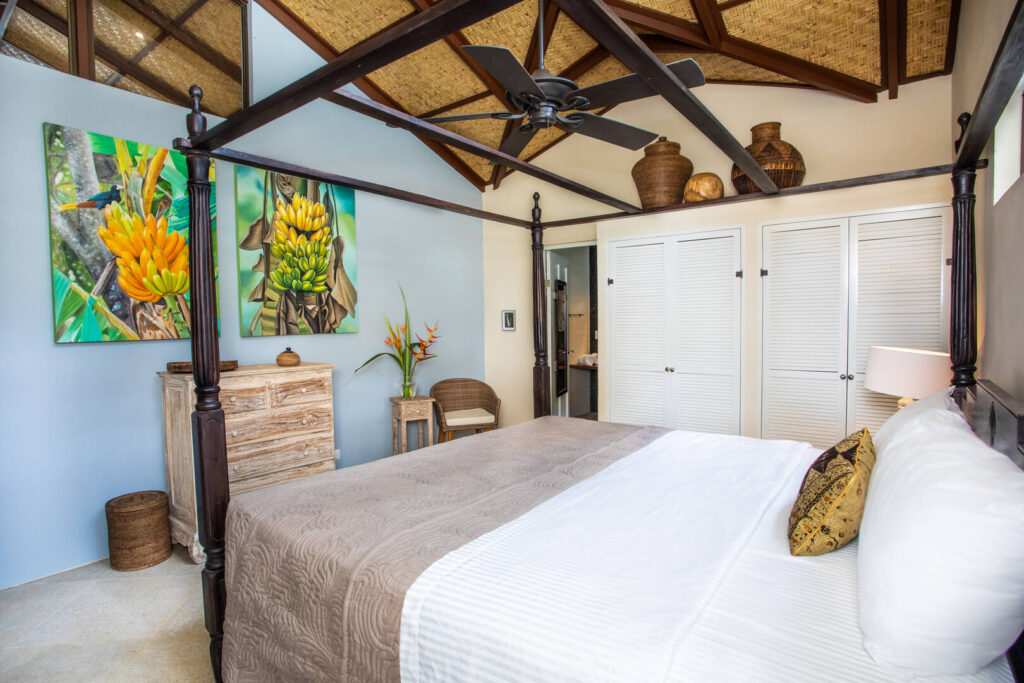 This bedroom is beautifully designed with natural vaulted ceilings and exotic artwork.