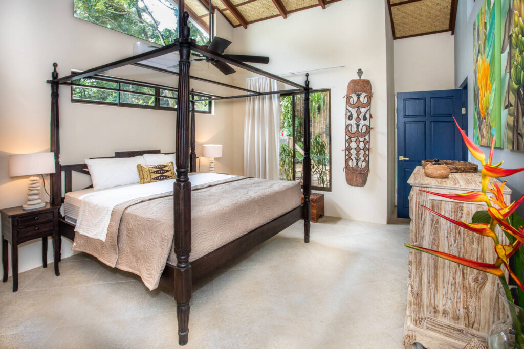 This bedroom has an abundance of natural light and a gorgeous handcrafted wooden poster king bed.