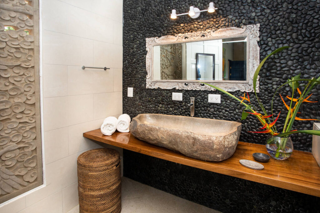 Dark natural stones contrast with light smooth tiles to create a truly unique design in this luxury bathroom.