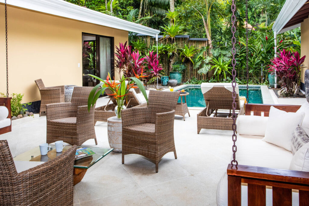 The courtyard area by the pool features a luxurious comfortable hanging couch.