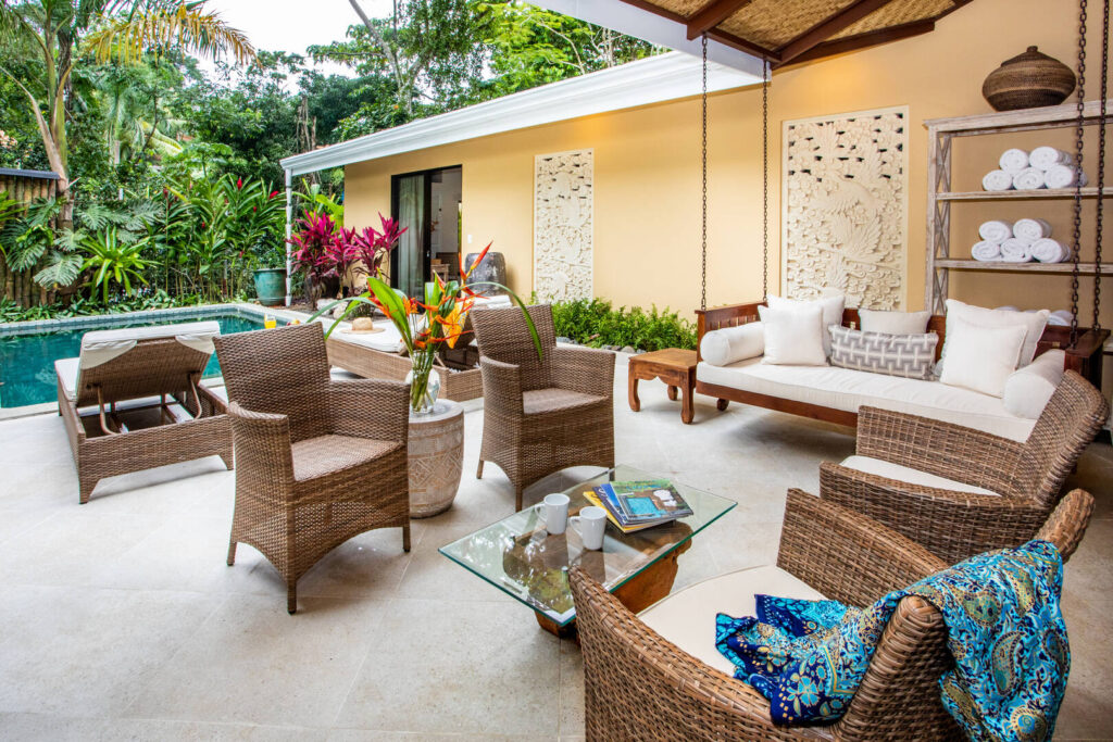 Wicker chairs offer a comfortable sitting area to relax by the pool.
