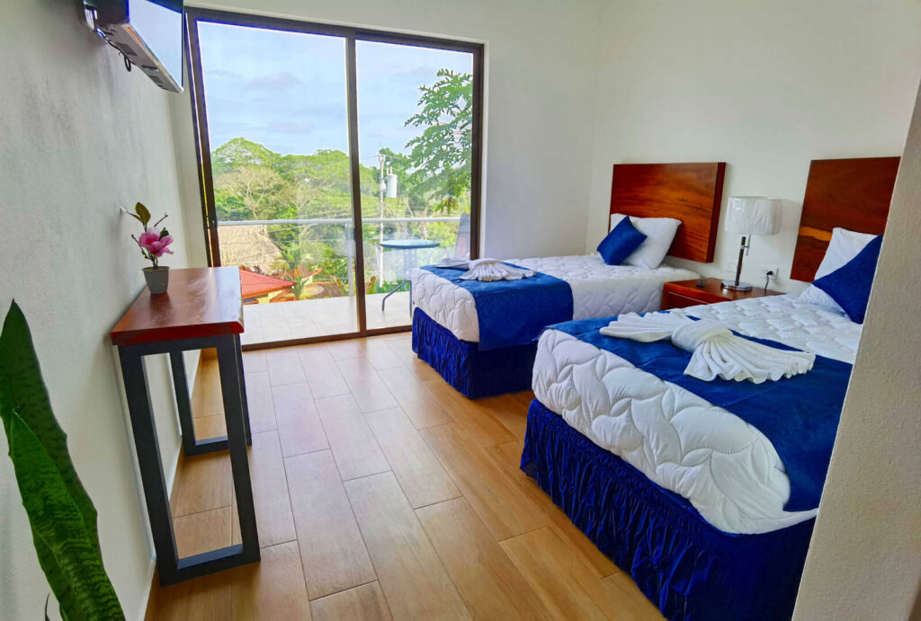 This bedroom with TV, wooden floor, and balcony sleeps two younger guests.
