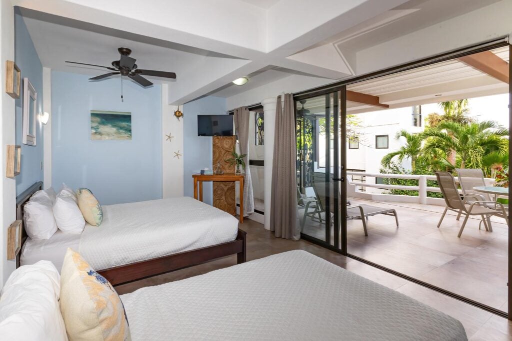 A bright twin bedroom with direct access to a private terrace, where indoor comfort flows easily into fresh air and relaxed outdoor moments.