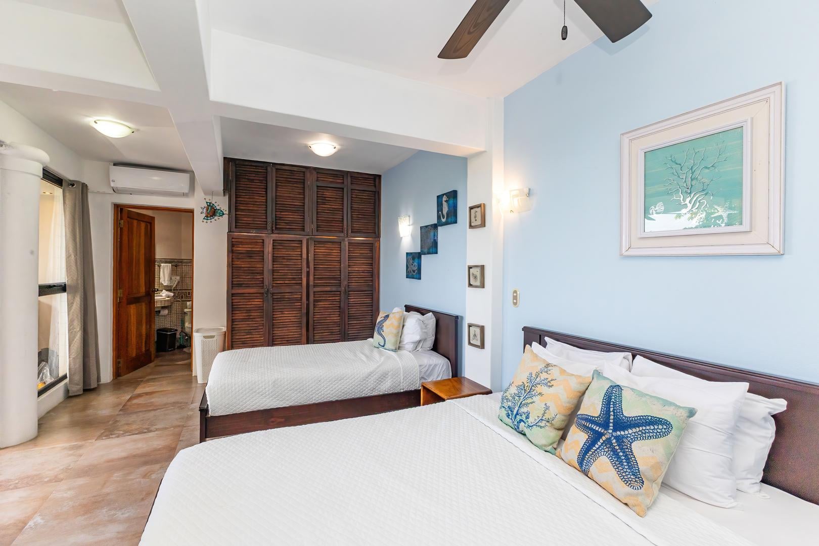 Twin bedroom with coastal colors, two beds, wooden floors, and natural light