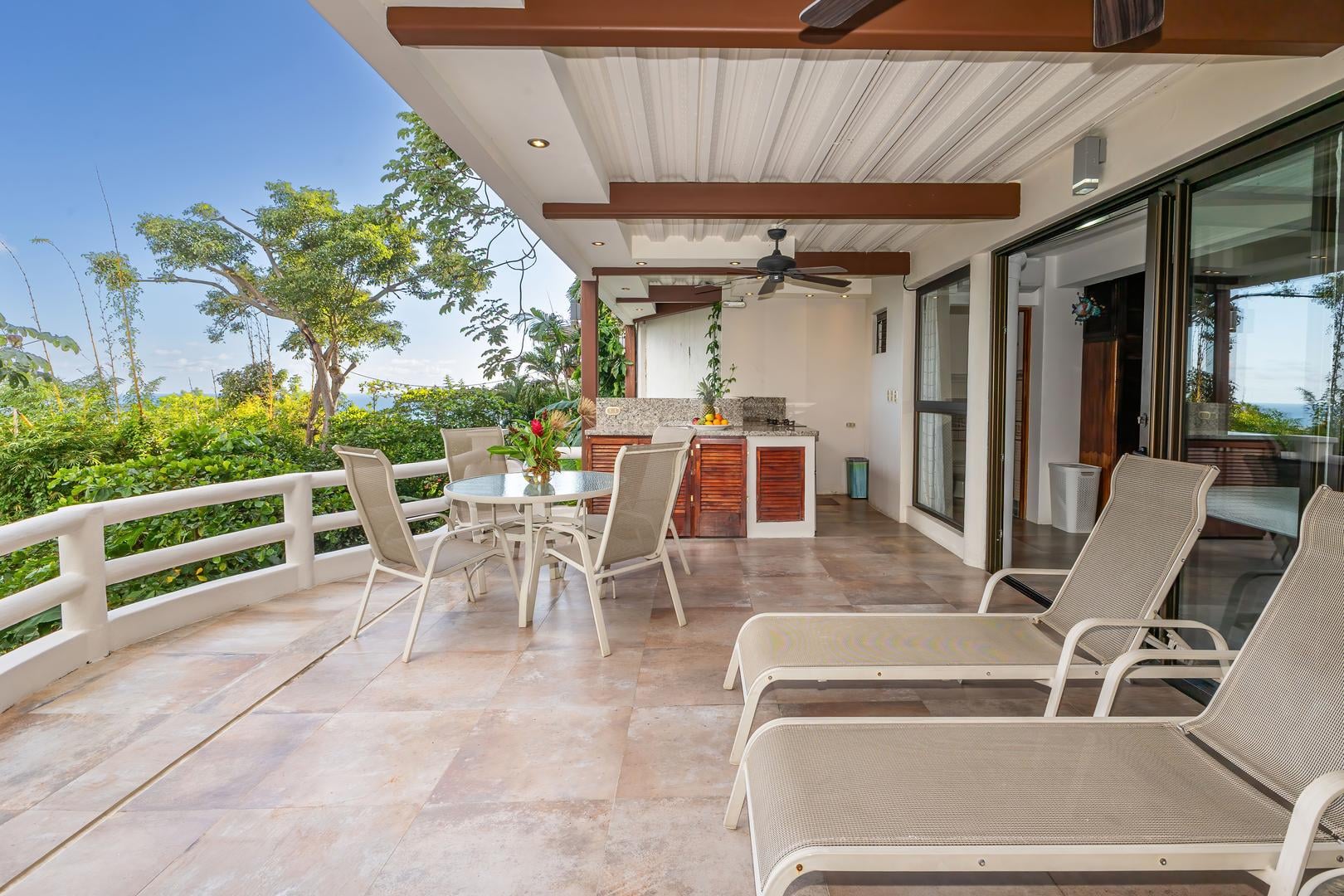 Covered terrace with outdoor dining table and seating accessed from a twin bedroom