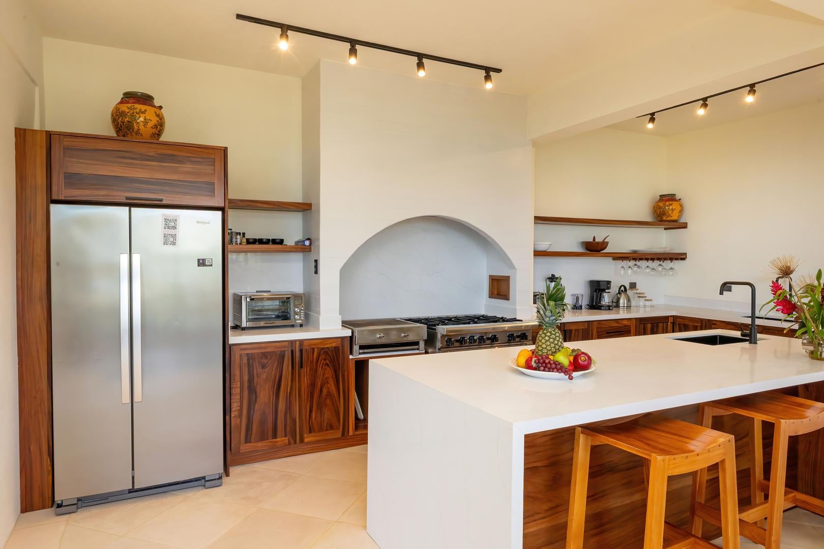 Kitchen with custom wood cabinetry, island seating, and modern appliances