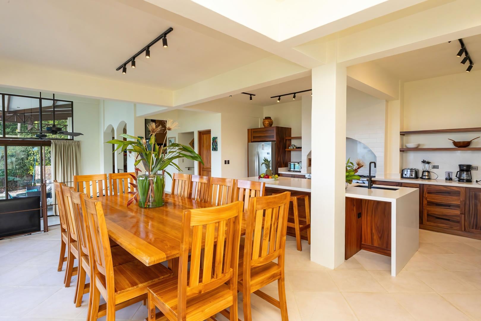 Open kitchen and dining area with wooden table, island seating, and natural light