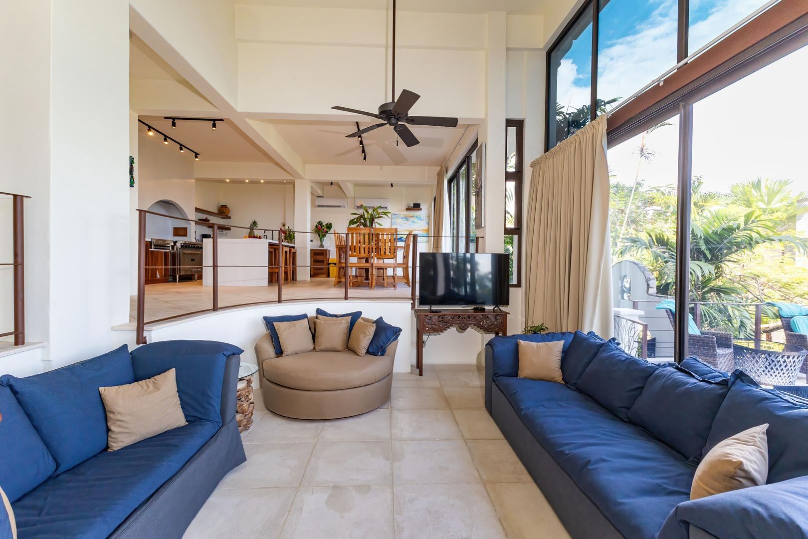 Sunken living area with sofas, open layout, and natural light