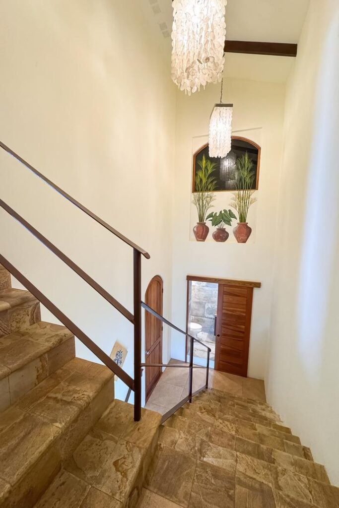 An elegant interior staircase with natural stone steps and soft lighting, creating a calm, welcoming transition between levels.