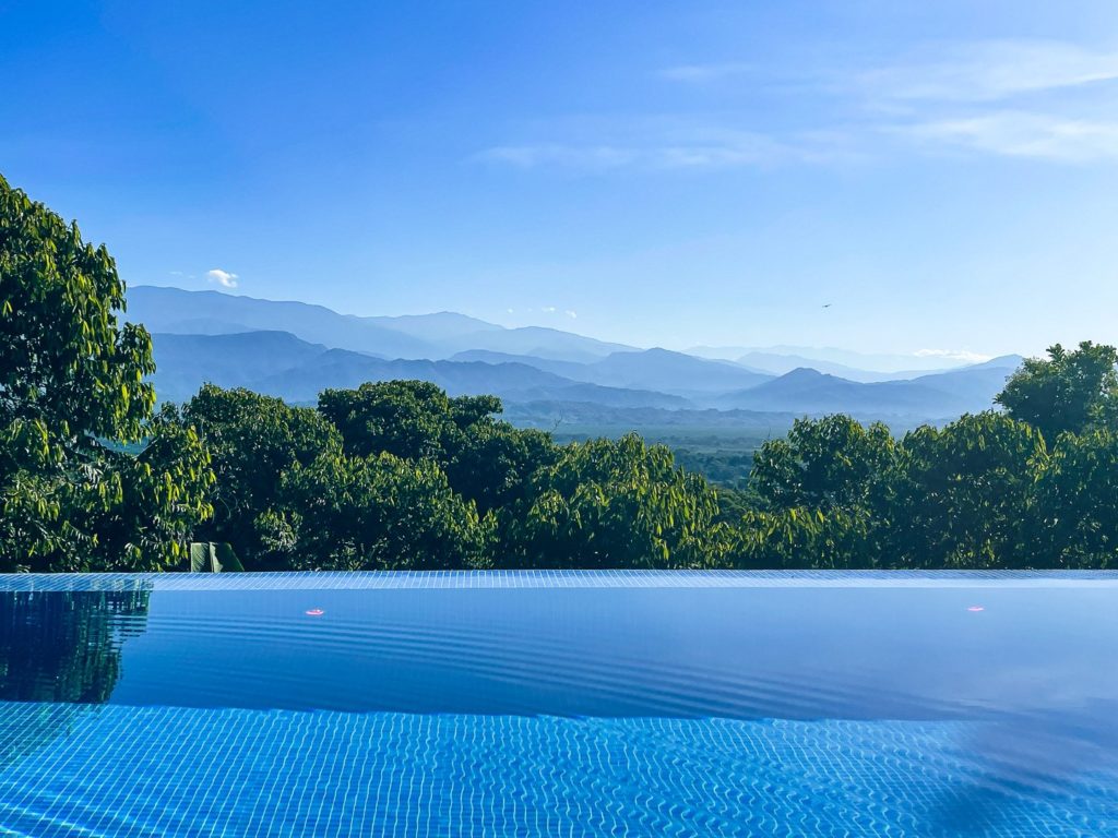 The stunning infinity pool overlooks endless lush green canopies.