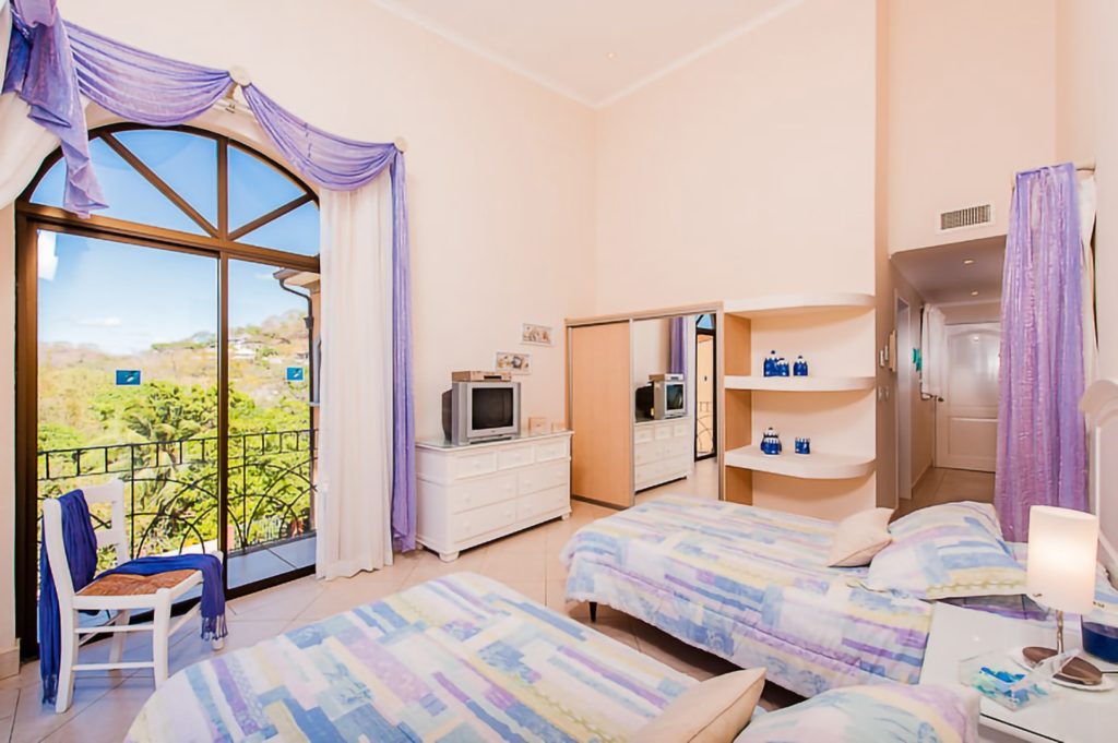 This bedroom has balcony access and a stunning view of Tamarindo.