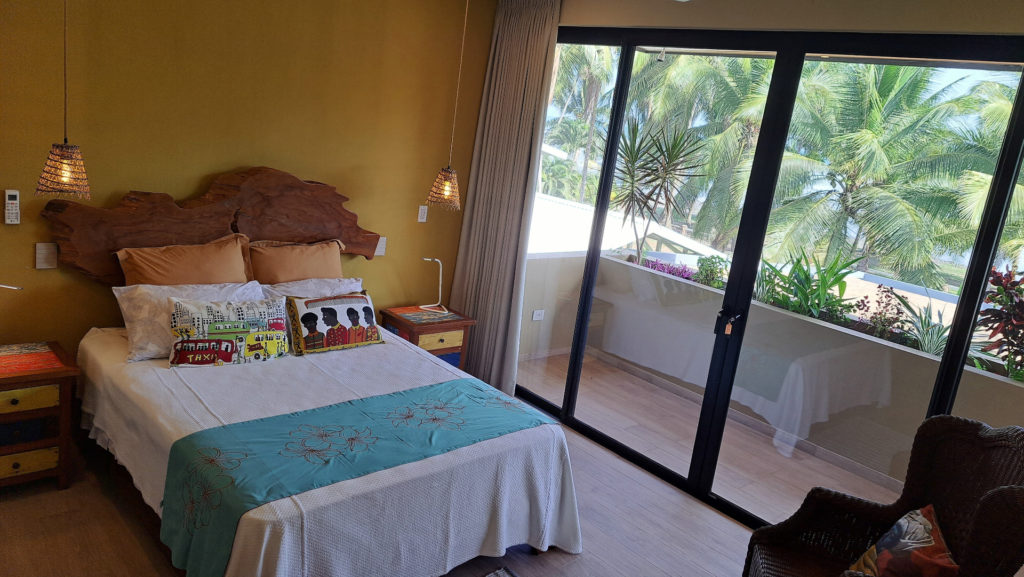The guest room features vibrant tropical decor and natural wood accents.