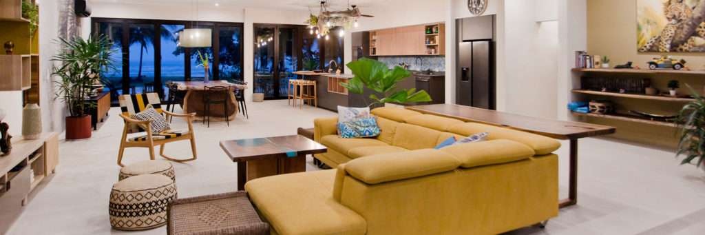 As night falls, enchantment graces this modern tropical open living space.