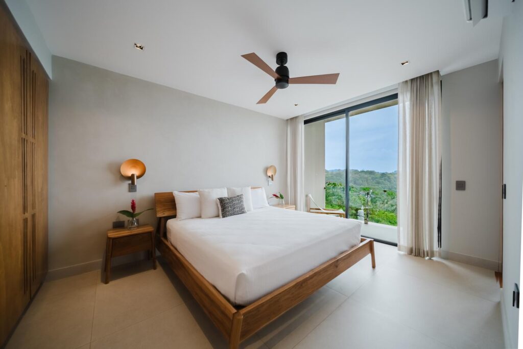 Light fills the room as the view opens gently to jungle and ocean beyond.