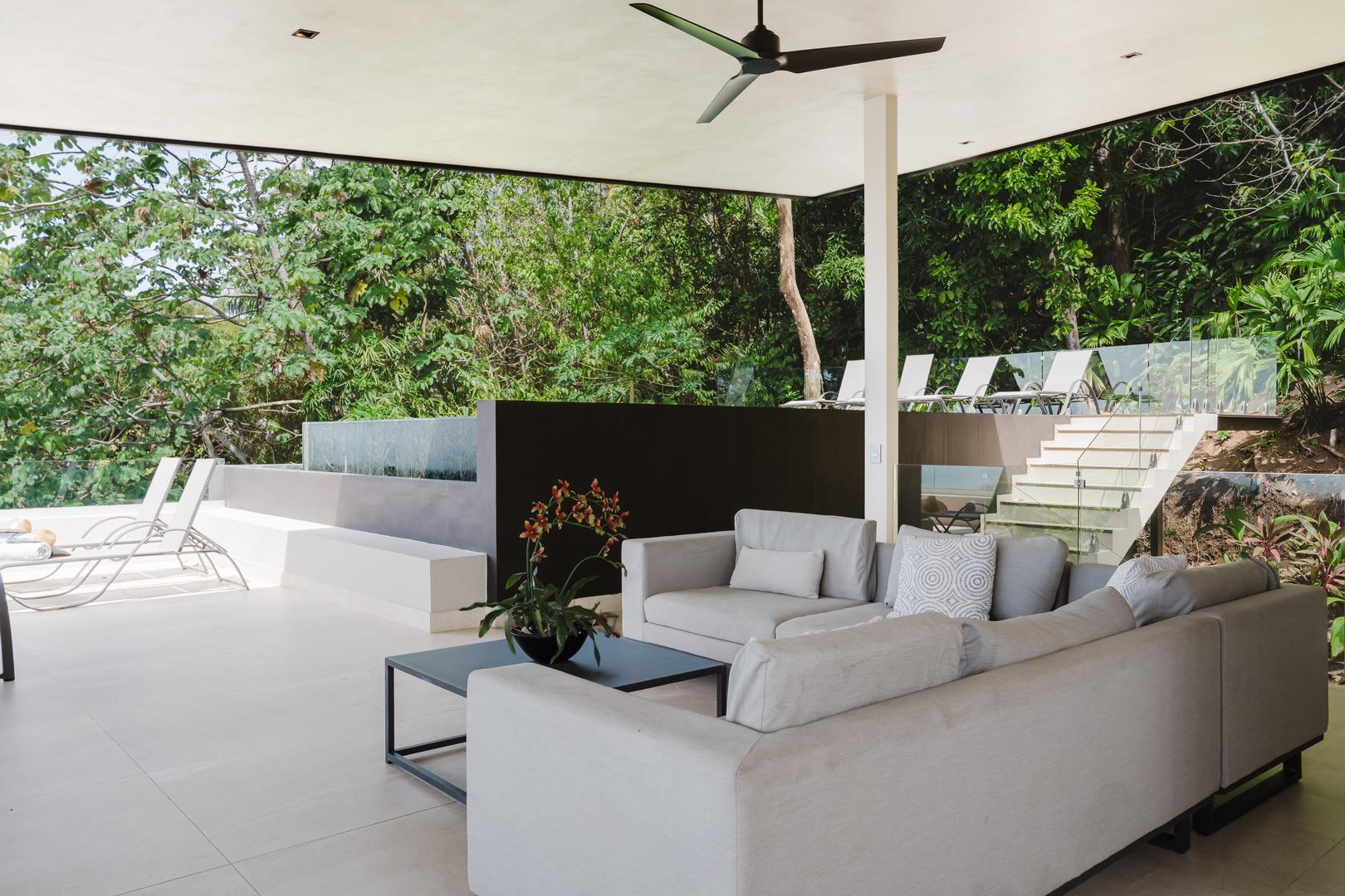 Open-air lounge seating next to pool surrounded by jungle Manuel Antonio Costa Rica