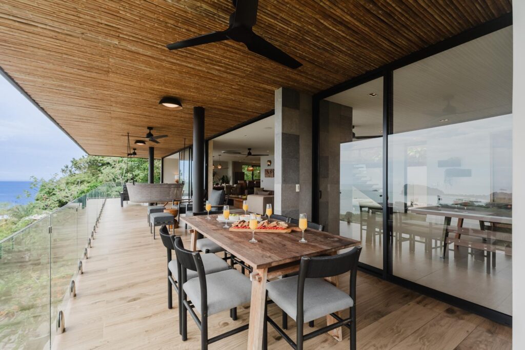 Dining unfolds beneath the terrace, with the ocean stretching quietly beyond.