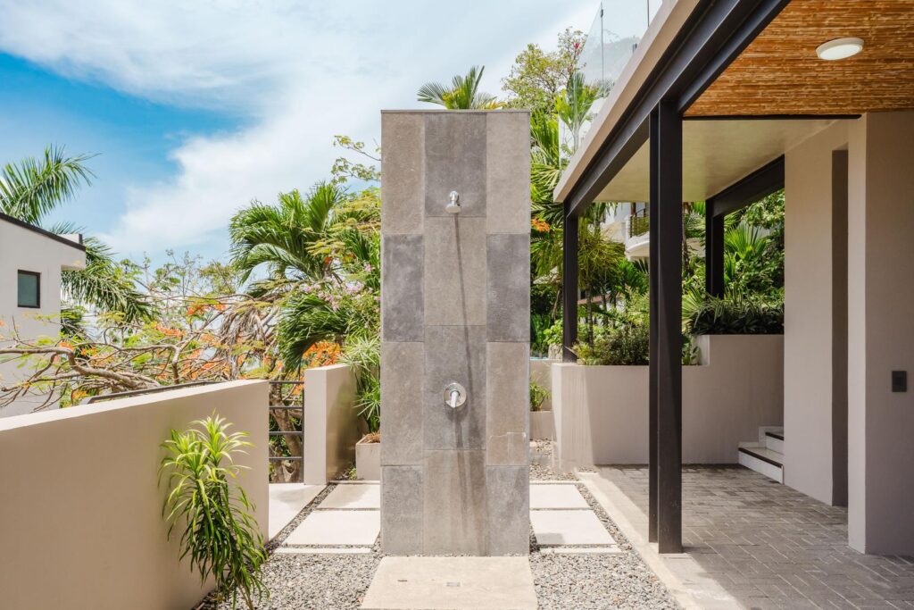 An open-air shower set within greenery, where the experience stays close to nature.