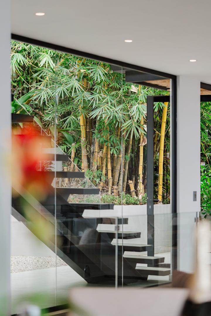 Modern floating staircase with glass railing and jungle view in Manuel Antonio Costa Rica