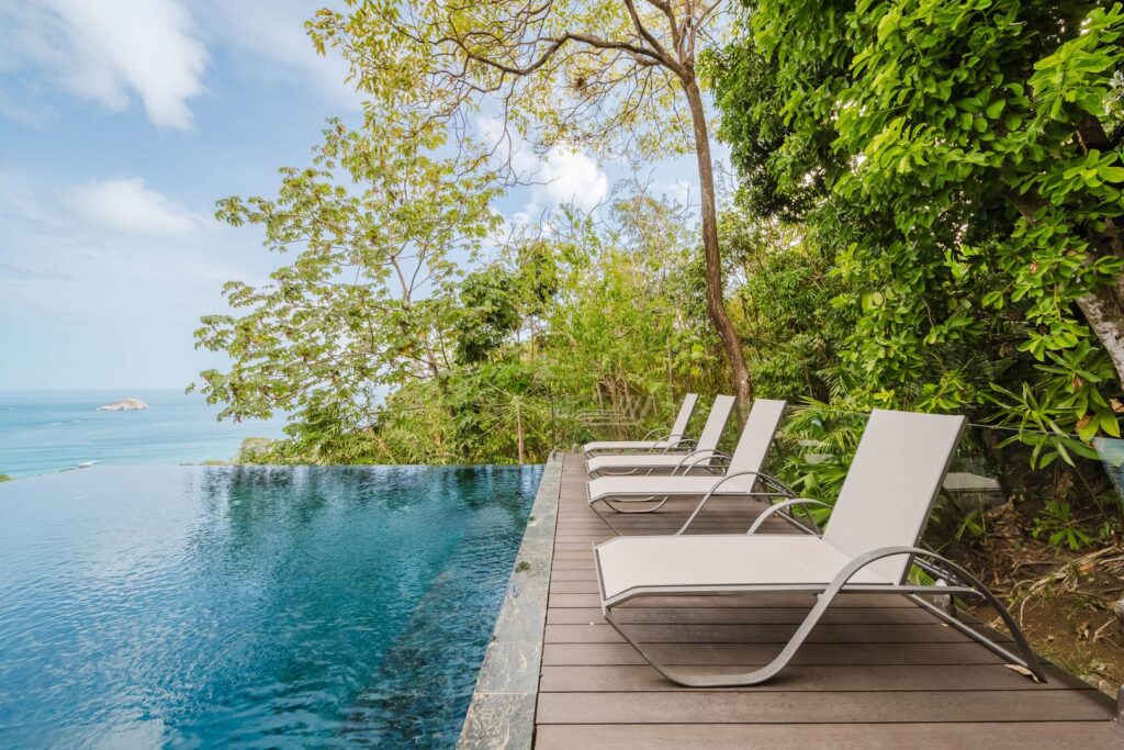 A quiet pool and sun deck where jungle and ocean settle into a single view.