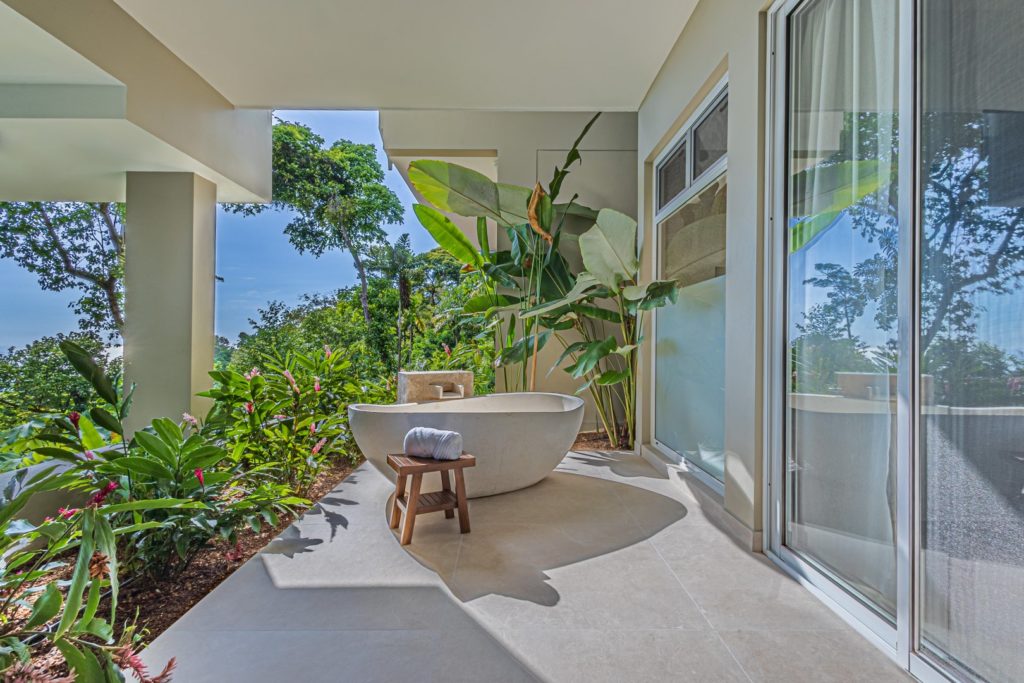 Enjoy a soothing soak in this luxury outdoor tub surrounded by tropical plants.