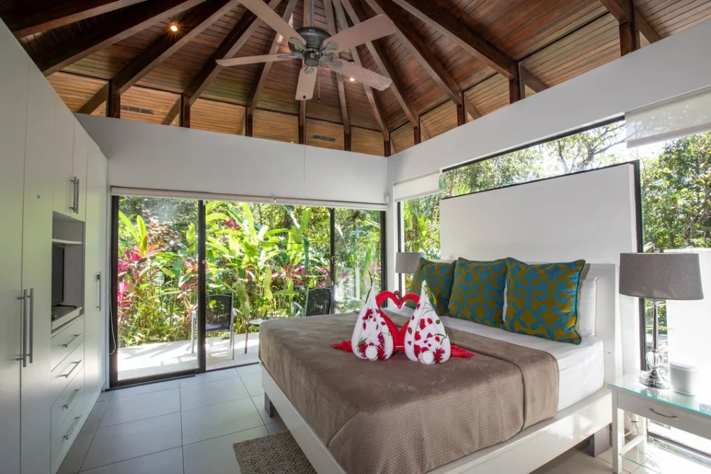 Serene elegance: A white modern bedroom retreat with a view to exotic gardens.
