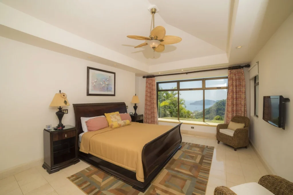 The luxurious master suite features floor-to-ceiling windows with incredible coastal and jungle views.