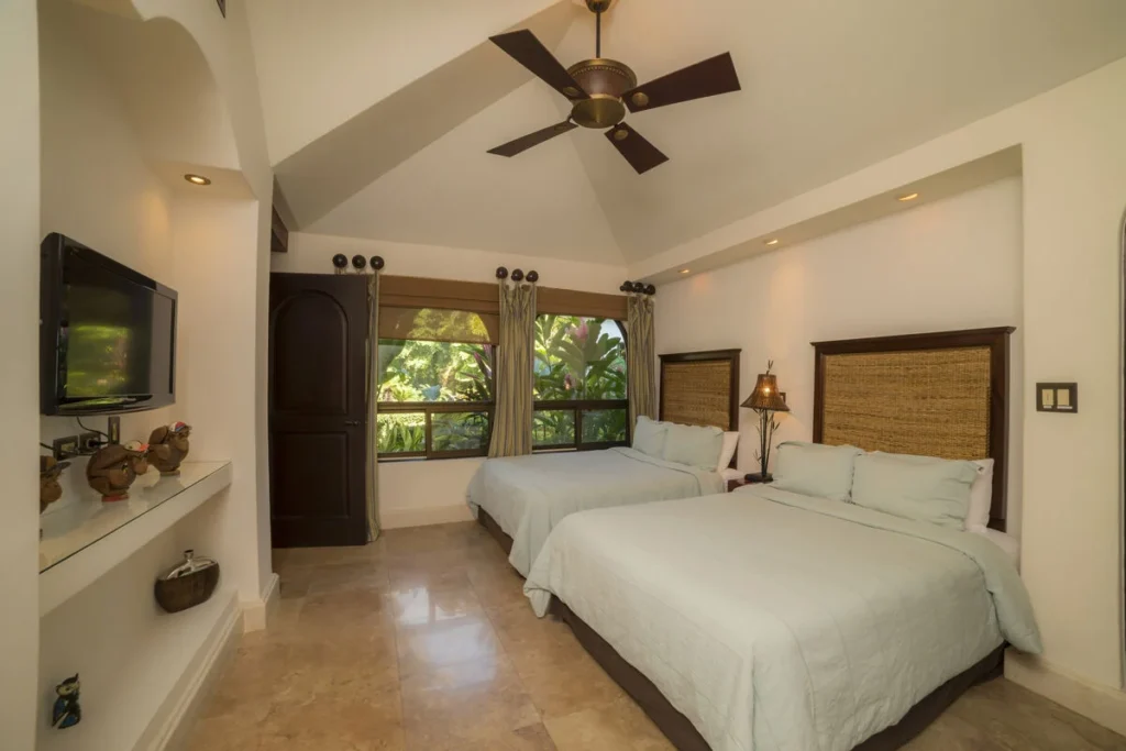 This bedroom showcases beautiful stone flooring and dramatic vaulted ceilings.