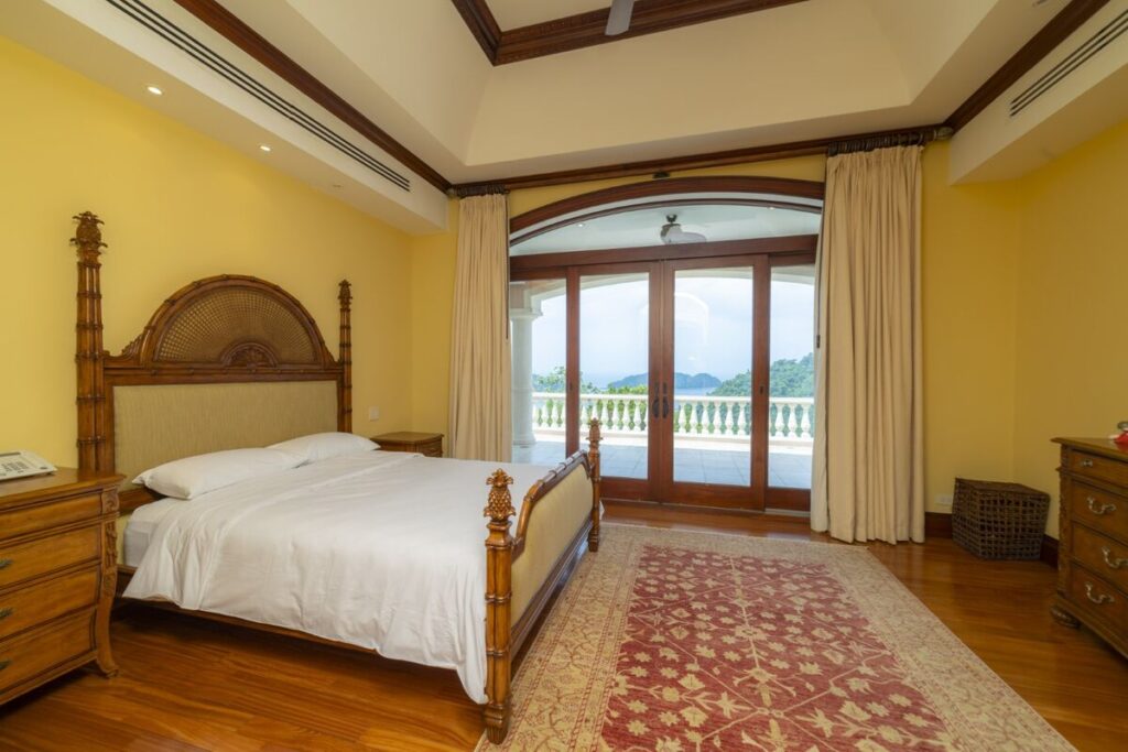 A serene guest bedroom with direct access to a private terrace overlooking the surrounding landscape.