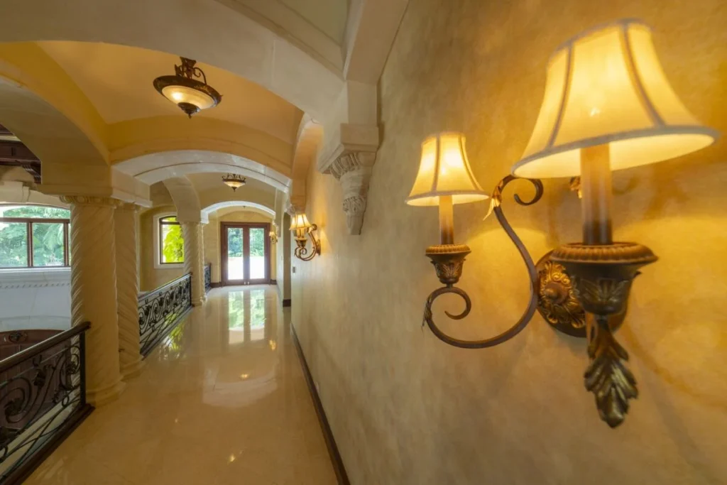 An elegant interior corridor defined by arched architecture, warm lighting, and refined finishes throughout.