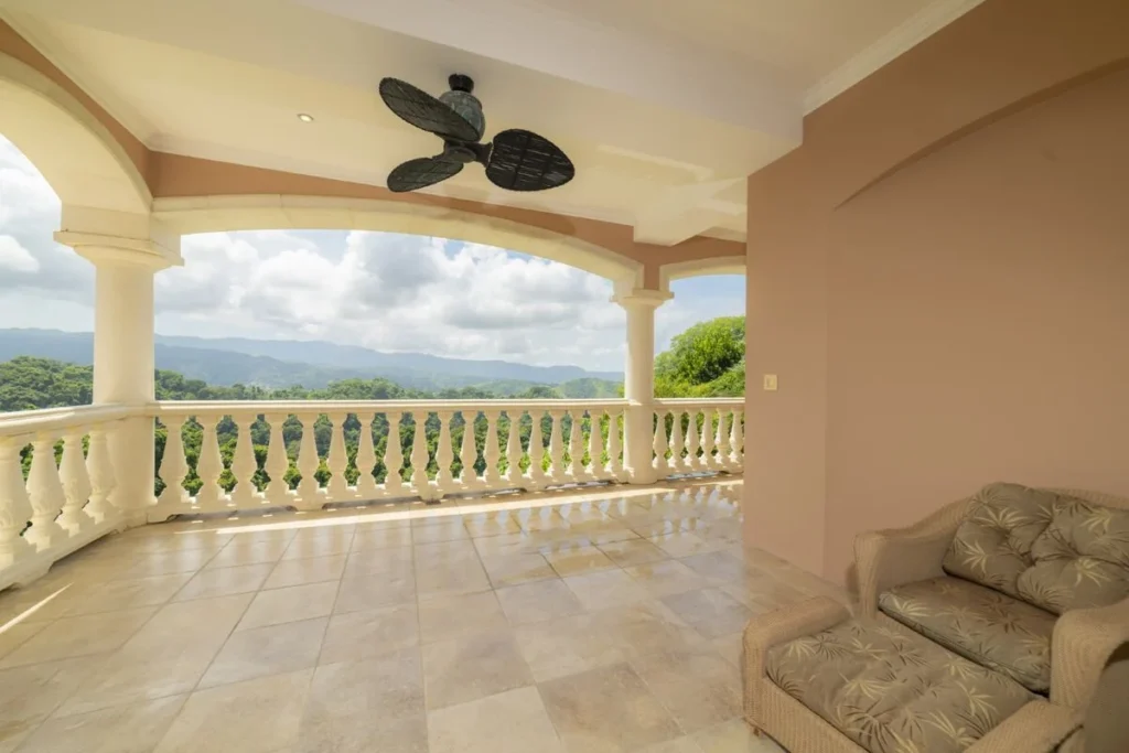 A quiet covered terrace with comfortable seating and expansive mountain views, offering a relaxed space to unwind in complete privacy.