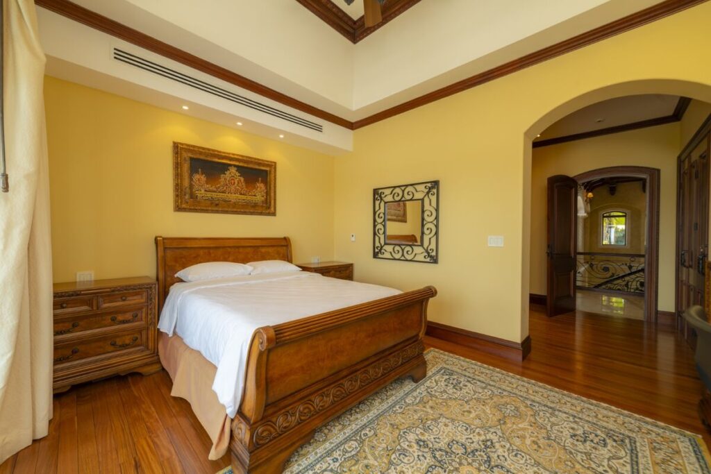 A spacious bedroom with warm finishes and refined furnishings, offering a comfortable and private retreat within the villa.