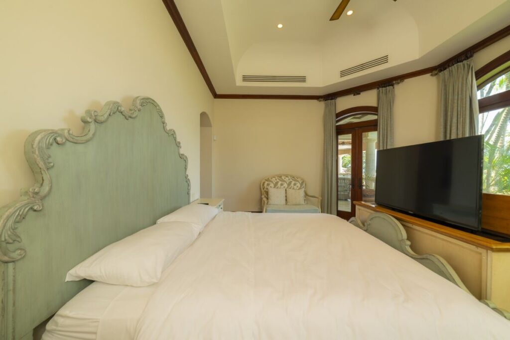 A comfortable bedroom with soft natural light and direct terrace access, offering a quiet and private retreat within the villa.